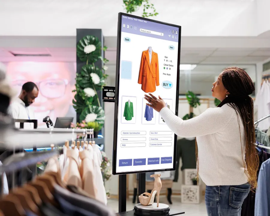 Shopper using an interactive retail kiosk in a clothing store